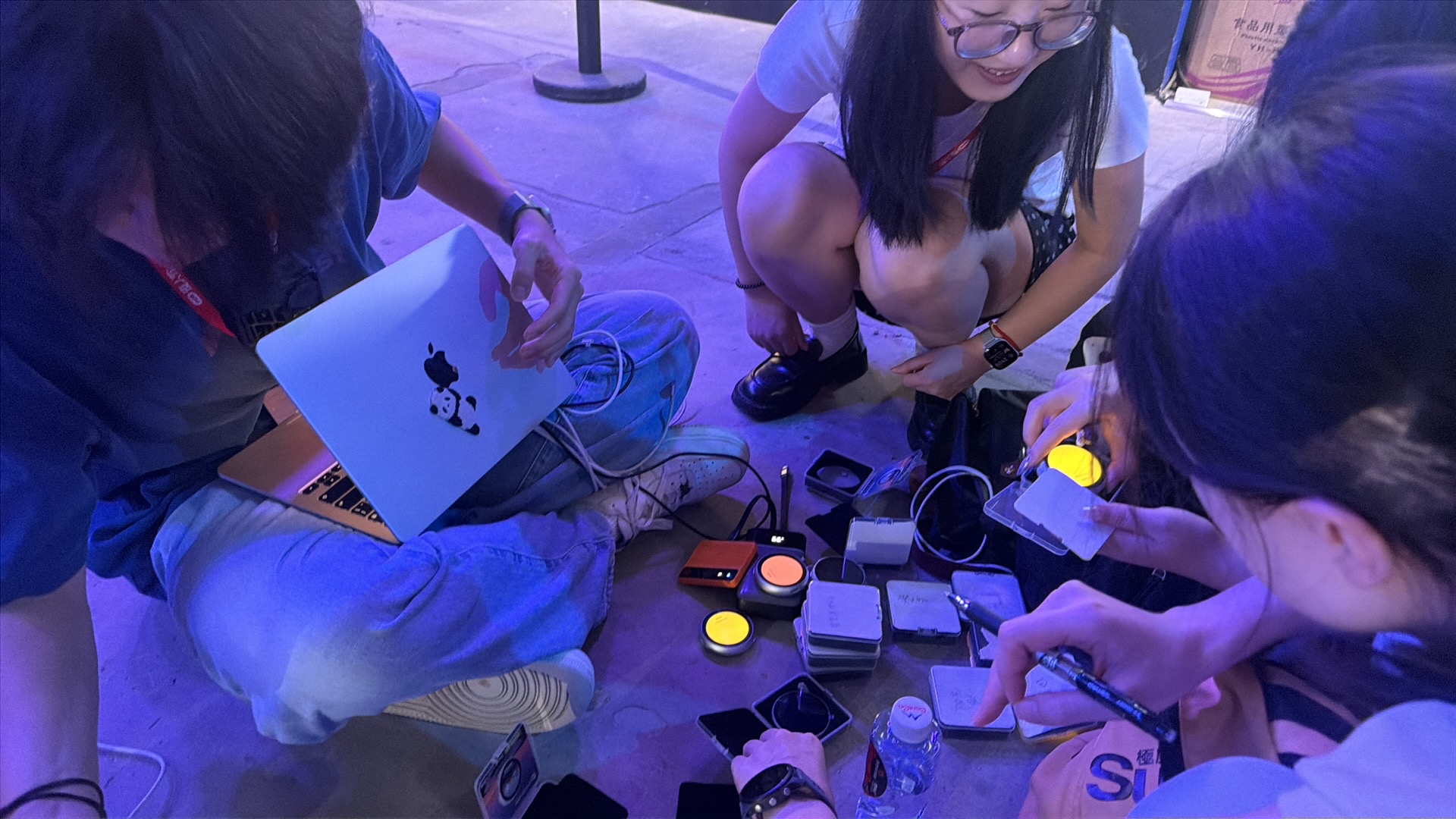 团队在活动现场席地而坐，调试亮起的回声并准备参与者资料